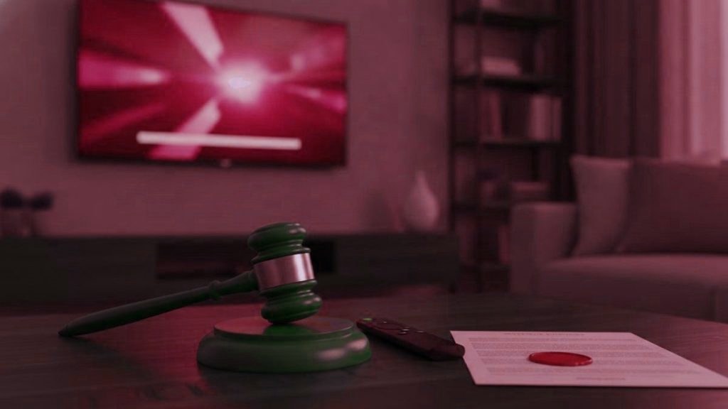 A judge gavel, a streaming remote and a sealed document on a coffee table in front of a TV